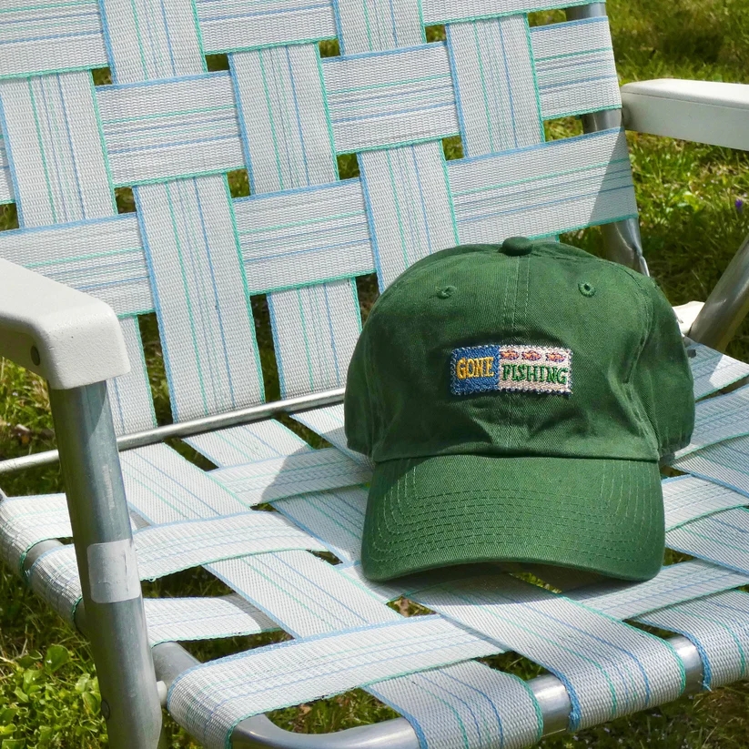 picture of green trucker hat with "gone fishing" vintage patch